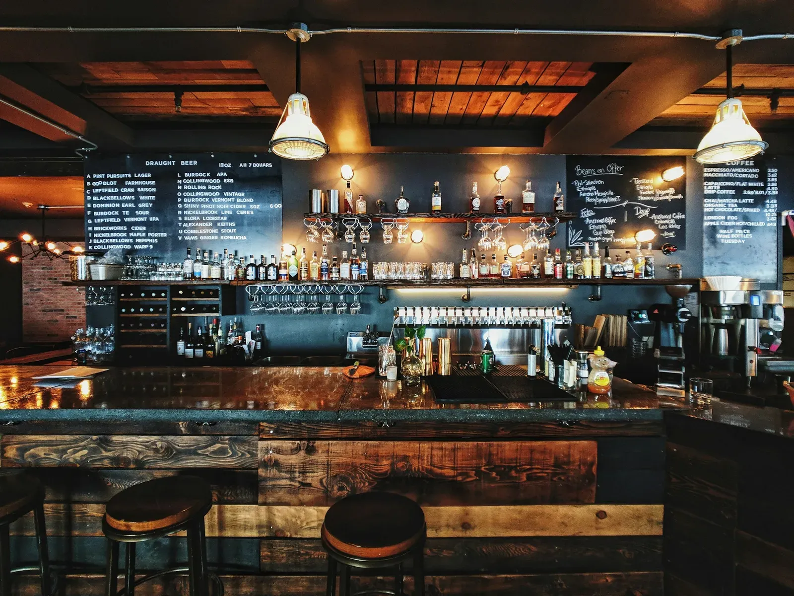 Bar back wall with taps, bottles, and chalkboard menus