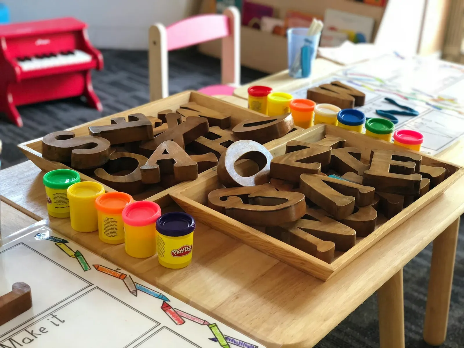 Day care table with wooden letters and play dough